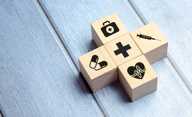 Krankenversicherungskonzept Holzblöcke mit medizinischem Ikonen im Gesundheitswesen auf blauem Hintergrund
