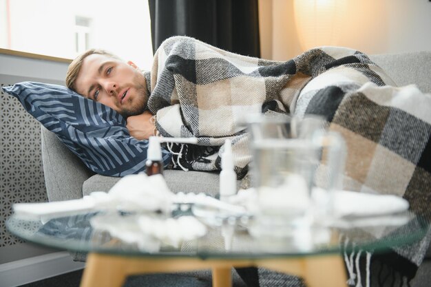 Kranker Mann liegt zu Hause auf dem Sofa