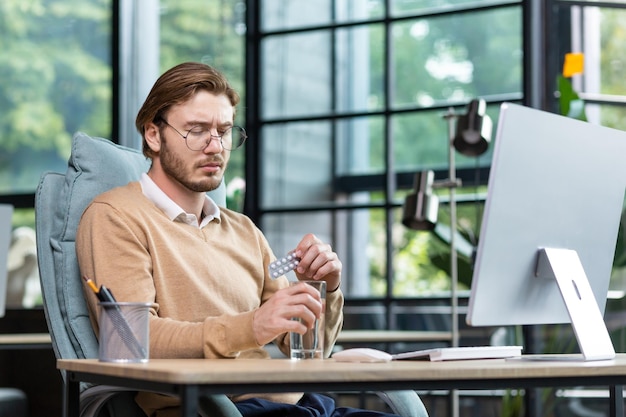 Kranker und übermüdeter Büroangestellter bei der Arbeit mit einem Computergeschäftsmann im Büro nimmt a