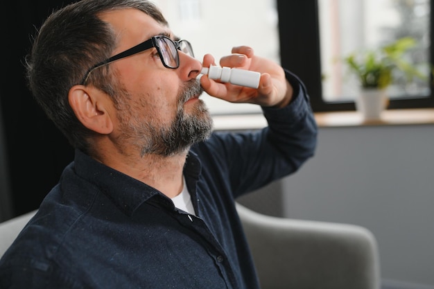 Krankheit und Krankheit Nahaufnahme des Menschen, der sich krank fühlt, tropft Nasentropfen in verstopfter Nase