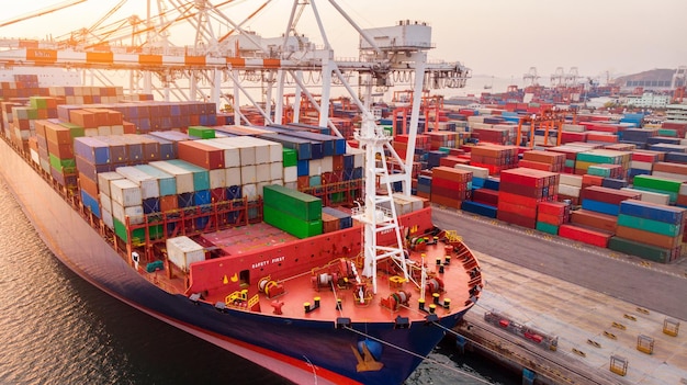 Kranverladung Frachtcontainer auf Containerschiff im internationalen Terminal Yard Port Konzept Frachtschifffahrt per Schiff bei Sonnenaufgang