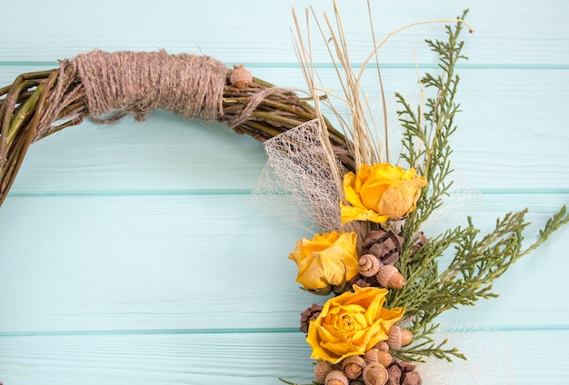 Kranz aus einer Rebe mit Rosen. Handgemachte decor.Wreath der realen Zweige auf einem hölzernen Hintergrund