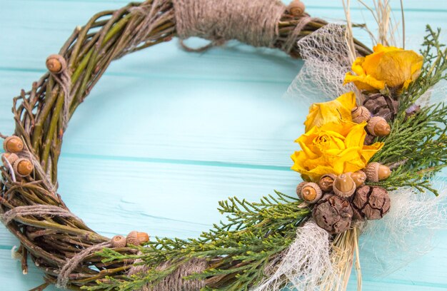 Kranz aus einer Rebe mit Rosen. Handgemachte decor.Wreath der realen Zweige auf einem hölzernen Hintergrund