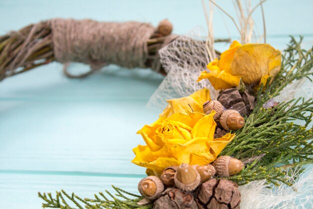 Kranz aus einer Rebe mit Rosen. Handgemachte decor.Wreath der realen Zweige auf einem hölzernen Hintergrund