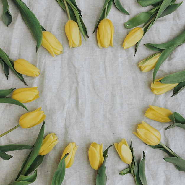 Kranz aus eleganten gelben Blumen mit leerem Mockup-Kopierraum auf beige zerknittertem Leinentuch Flach gelegt Top-View Brand-Blog-Website Social-Media-Vorlage