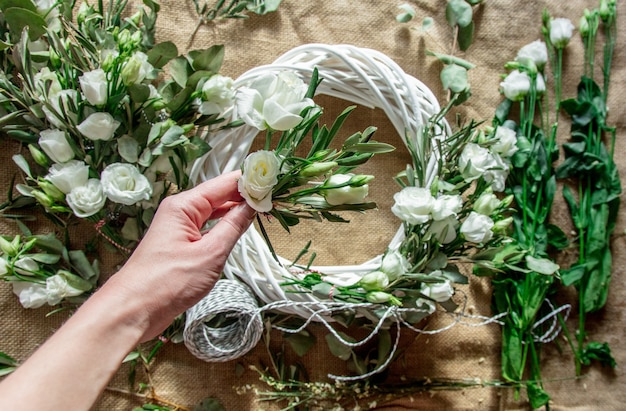 Kranz mit weißen Rosen auf Jutehintergrund. Dekoriert