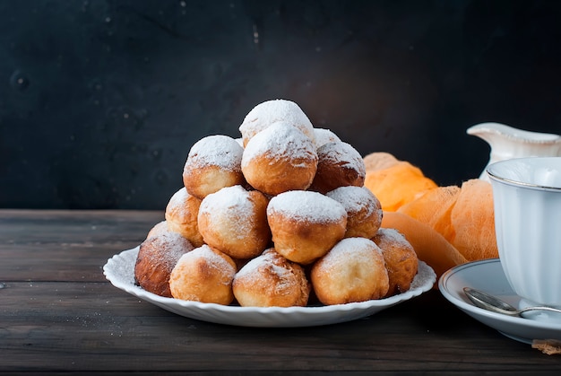 Krapfen ausgebreitete Pyramide mit Puderzucker bestreut auf dunklem,