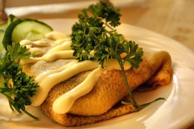 Krapfen mit einer Füllung, dekoriert mit Petersilie und einer Gurke, im Restaurant