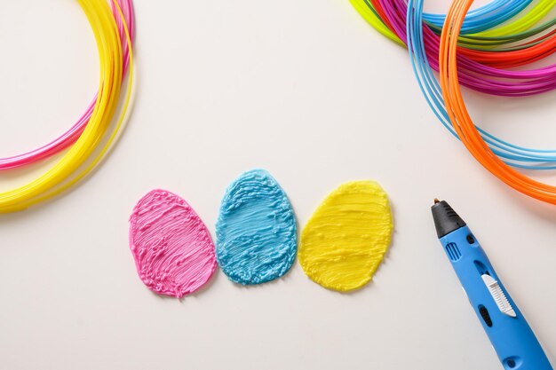 Foto kreative bunte eier aus kunststoff für osterferien regenbogen-kunststofffilamente mit stiftverlegung