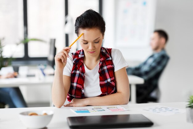 Foto kreative frau, die im büro an der benutzeroberfläche arbeitet