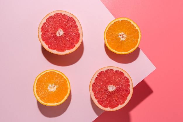 Kreative Fruchtzusammensetzung auf rosa Hintergrund mit harten Schatten