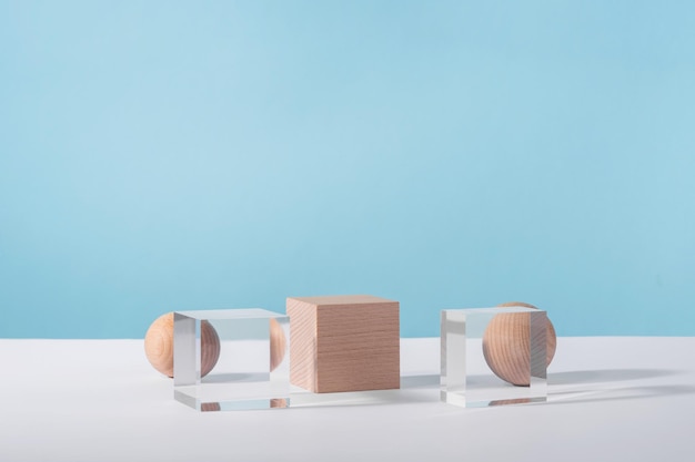 Kreative geometrische Produktbühne Mock-up Kosmetik-Display-Plattform Kosmetik präsentiert geometrischen Stand Holz- und Glaswürfel Podium und Kugel auf blauem Hintergrund für Produktwerbung