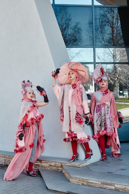 Kreative Kleidung der Mädchen in der neuen Mode-Mode, die auf der Straße, dem rosa Kleid und dem Hut, ethnische Kleidung aufwirft