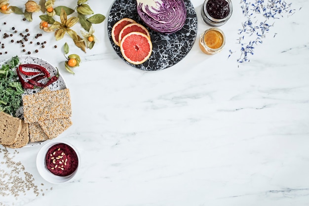 Kreative Komposition der modernen Küche mit Kopienraum und Auswahl an gesunden Lebensmitteln: Obst, Gemüse, Superfood, Samen. Marmor Hintergrund.