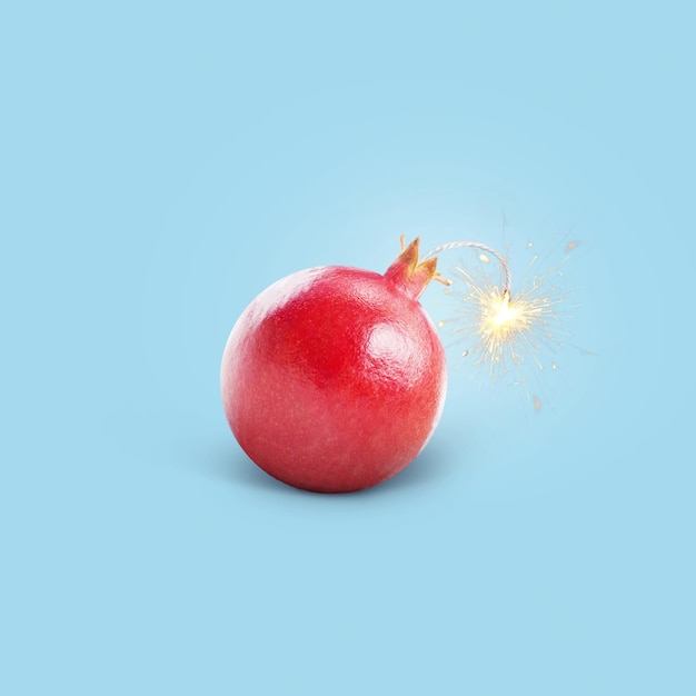 Foto kreative saftige bombe granatapfel mit einem docht mit funken brennend auf blauem hintergrund konzept vitamine und gesunde ernährung kreative idee diät und stärkung der blutgefäße immunität