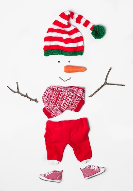 Kreative Schneemannform aus Santa elf39s Hut und verschiedenen Gegenständen auf weißem Hintergrund flach gelegt