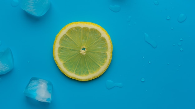 Kreative Sommerhintergrundkomposition mit Zitronenscheibe und Eiswürfeln. Minimales Konzept des Limonadengetränks von oben nach unten. Spas kopieren.