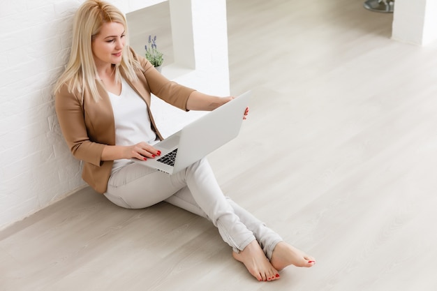 Kreativer Arbeitsbereich, Frau arbeitet online am Laptop zu Hause