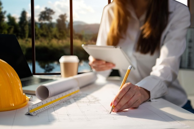 Kreativer Architekt, der im Morgenlicht auf die großen Zeichnungen im dunklen Loft-Büro oder Café projiziert