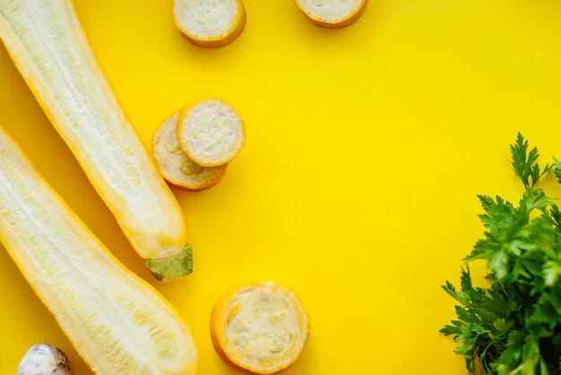 Kreativer Plan der festen und geschnittenen gelben Zucchini auf gelbem Hintergrund