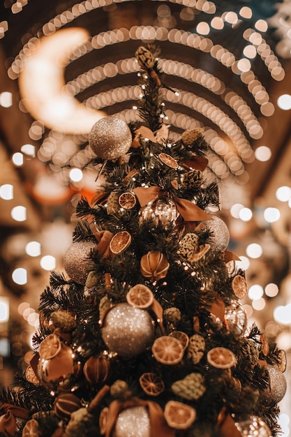 Kreativer Weihnachtsbaum dekoriert mit trockenen Orangen Mandarinen Tannenzapfen Magische gemütliche Details