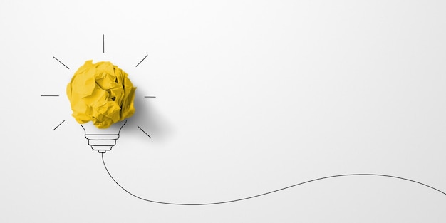 Foto kreatives denken ideen und innovationskonzept. papierschrottball gelbe farbe mit glühbirnensymbol auf weißem hintergrund