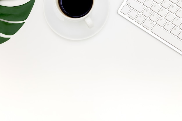 Kreatives flaches Lagefoto des modernen Arbeitsplatzes mit Laptop, Draufsichtlaptophintergrund und Kopienraum auf weißem Hintergrund, über der Ansicht geschossen von den Computern auf weißem Hintergrund