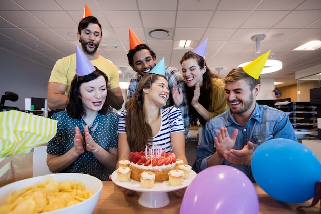 Kreatives Geschäftsteam, das Kollegengeburtstag im Büro feiert