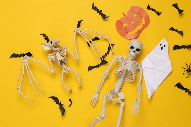 Kreatives Halloween-Layout Vampirfledermaus-Skelettgeister und fliegende Fledermäuse auf gelbem Hintergrund Flache Ansicht von oben