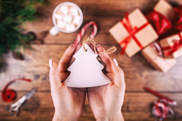 Kreatives Hobby. Die Hände der Frau zeigen handgemachtes Weihnachtsbaumspielzeug des Weihnachtsfeiertags