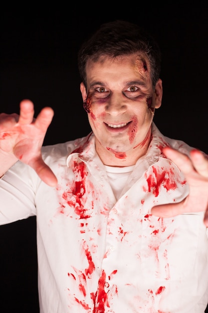 Kreatives Make-up des Mannes, der für Halloween wie Zombie verkleidet ist.