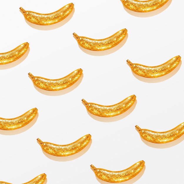 Kreatives Muster einer goldenen Banane auf weißem Hintergrund. Kreativer Hintergrund.