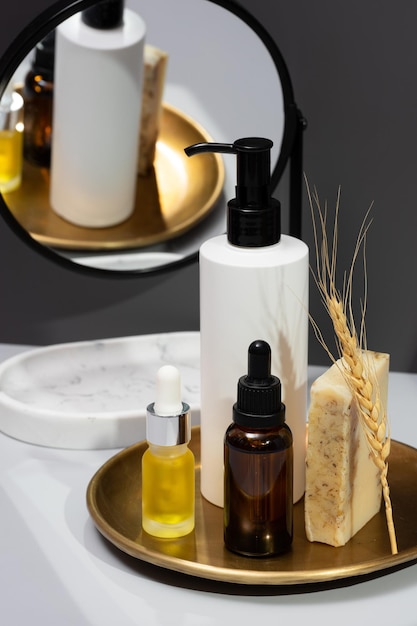 Kreatives Stillleben mit Naturkosmetik Set aus Serumölen Handgemachte Seife und Spiegel auf dunkelgrauem Hintergrund Das Konzept der Selbstpflege und Bio-Produkte Spiegelung im Spiegel