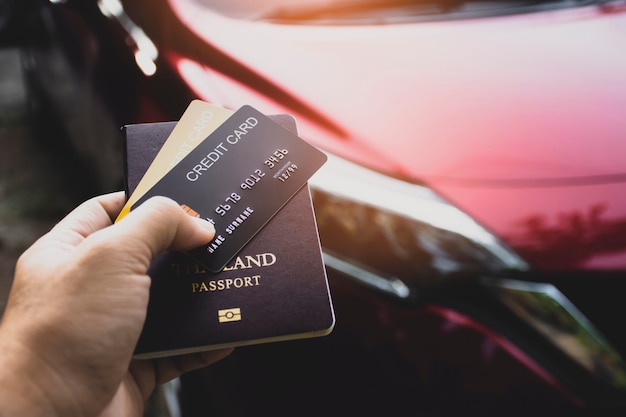 Kreditkarte und Reisepass für internationale Autovermietung in touristischer Hand