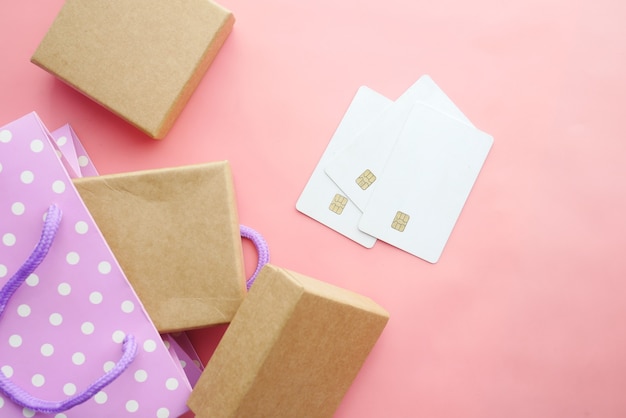 Kreditkarten und Geschenkbox auf rosa Hintergrund