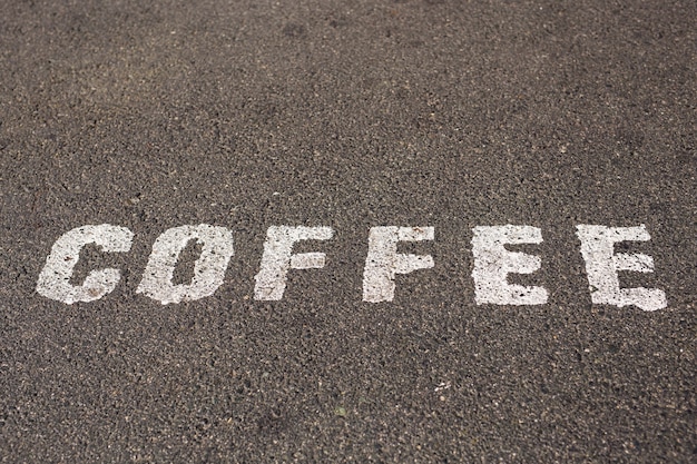 Kreidefarbe des Wortes KAFFEE auf Asphalt.