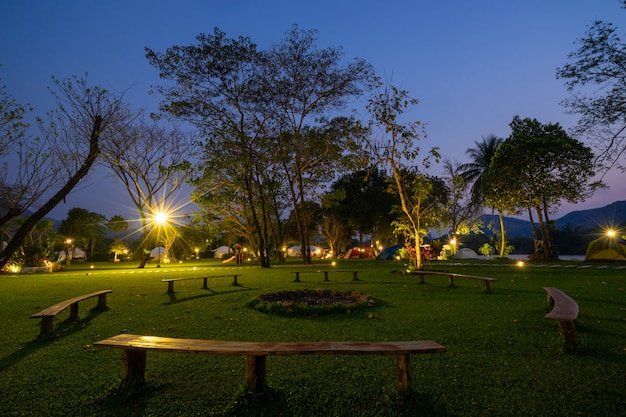 Kreisbank unter einer Lampe im Park nachts