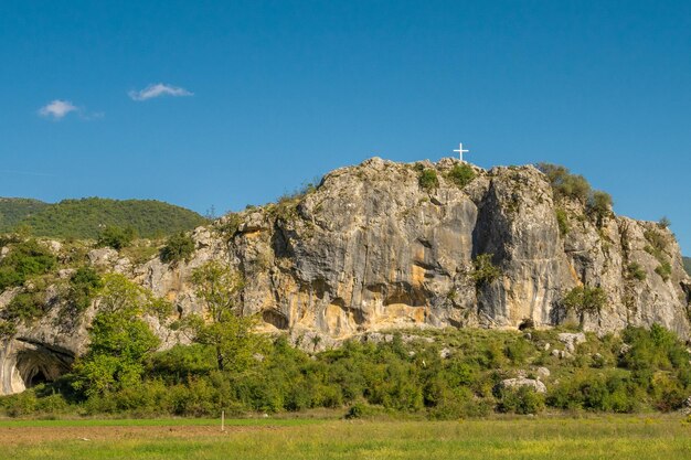 Kreuz auf dem Hintergrund der Berggipfel