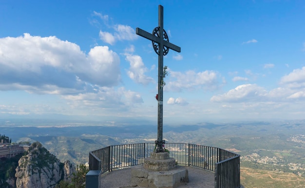 Kreuz Jesu Christi. Ostern, Auferstehungskonzept. Christliches Eisenkreuz auf einem Hintergrund mit dramatischer Beleuchtung, farbenfrohem Bergsonnenuntergang, Wolken und Himmel, Sonnenstrahlen