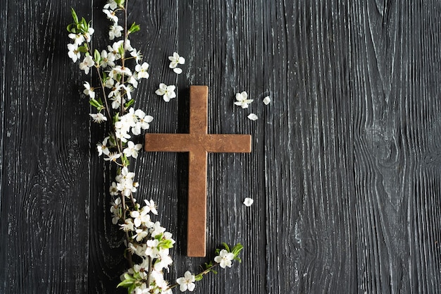 Kreuz mit Blumen auf einem hölzernen Hintergrund mit der Inschrift "Christus ist auferstanden"