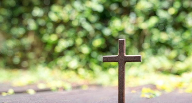 Kreuz mit grünem Bokeh-Naturhintergrund