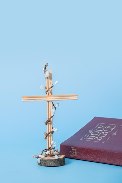 Kreuz verzierte Blumen mit Bibel auf blauem Hintergrund Minimalistisches Konzept für die Osterferien