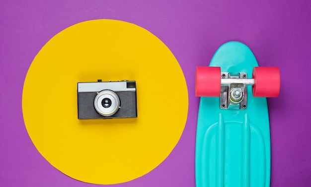 Kreuzerbrett und Retro-Filmkamera auf lila mit gelbem Kreis