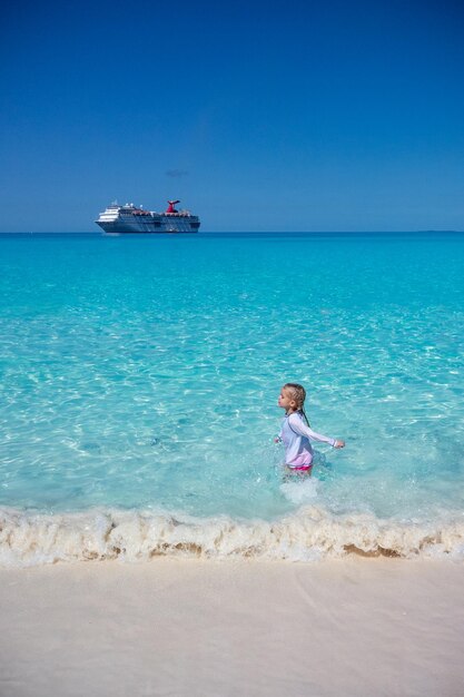 Kreuzfahrt vor der Küste Mädchen spielt am Strand Hellblauer Himmel und Wasser