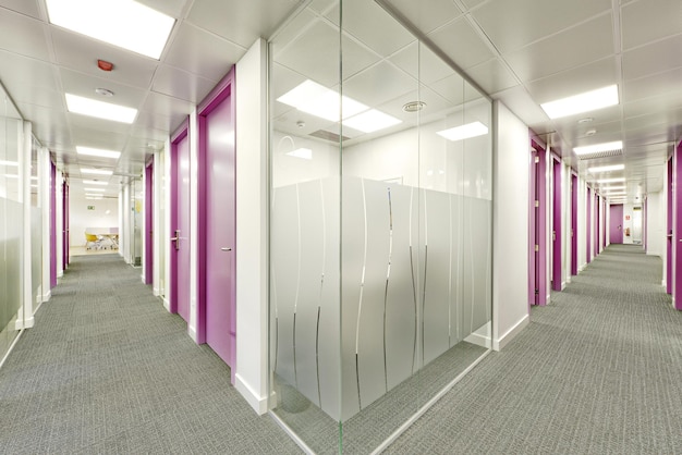 Foto kreuzung von bürokorridoren mit glaskabinen und grauen teppichböden
