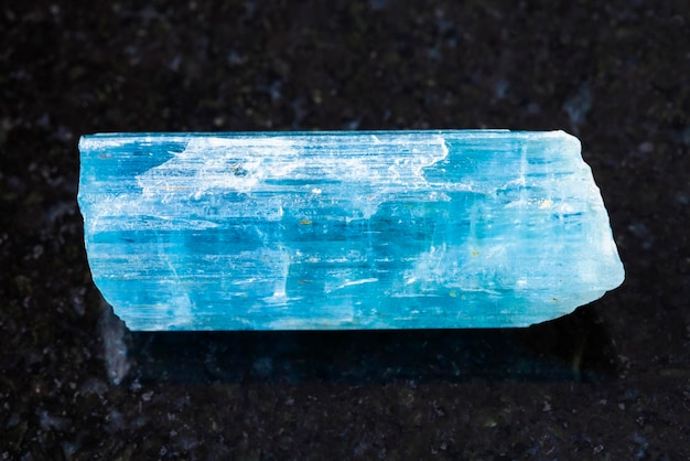 Kristall aus aquamarinblauem Beryllstein auf dunkel