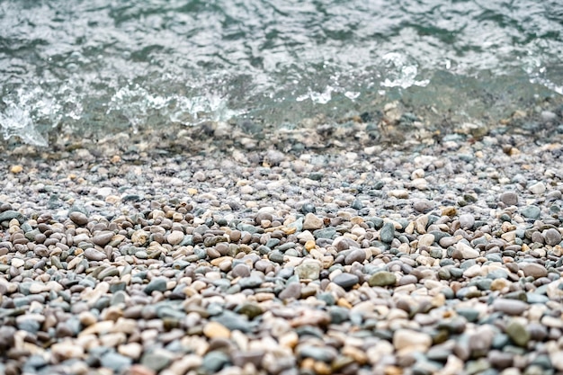 Kristallklares Wasser wäscht Kieselsteine, die am Strand des Meeres in der Nähe liegen