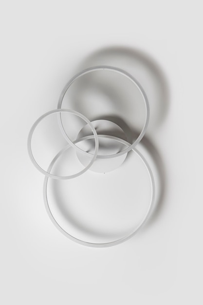 Kronleuchter in Form von drei Ringen vor einer weißen Decke