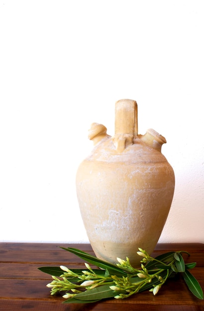 Krug auf weißem Hintergrund und auf Holzbrettern mit aufrechtem Foto mit weißen Blumen