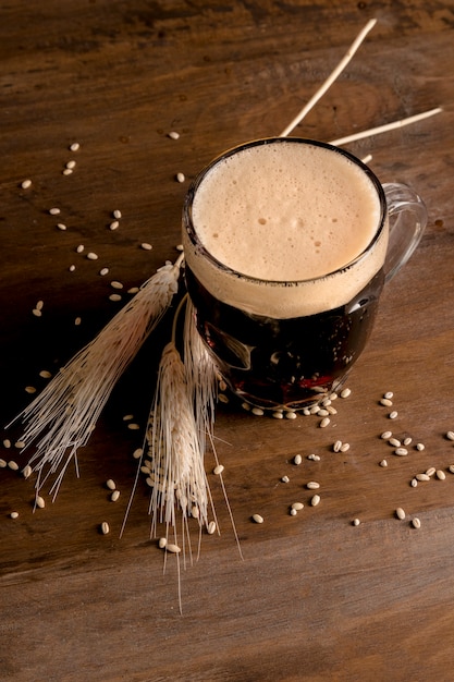 Foto krug bier mit spitzengerste auf holztisch